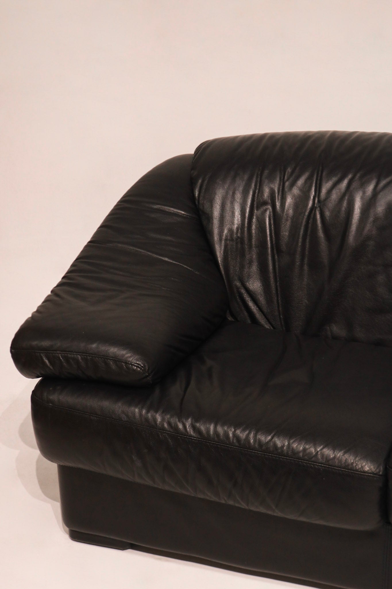 Front detail black leather upholstery showing padded cushion and armrest form