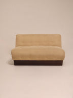 Full front view of two-seater beige sofa with channel tufted backrest