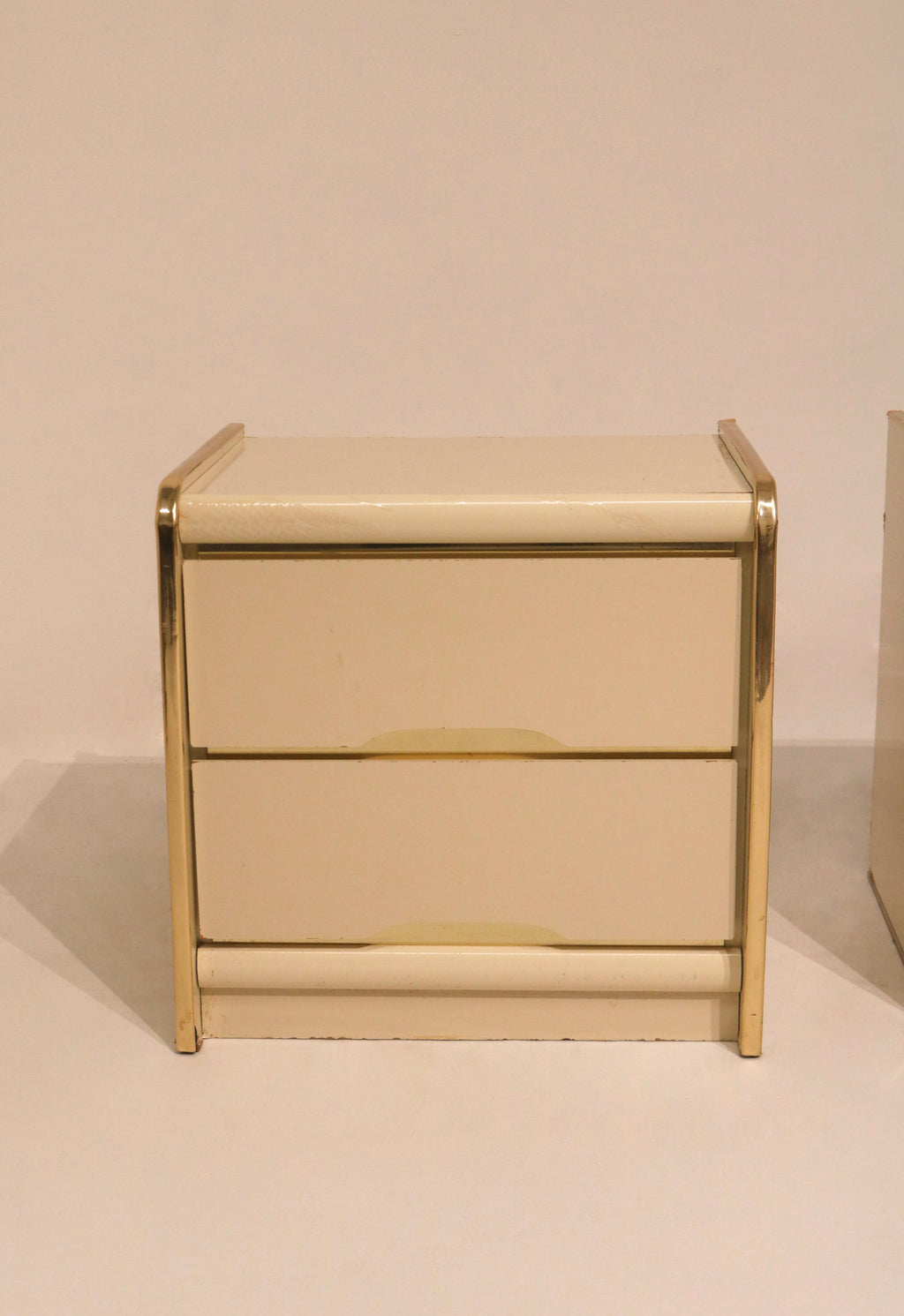 Front view of single nightstand with two drawers and gold accents