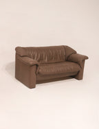 Full perspective view of the brown leather couch in studio