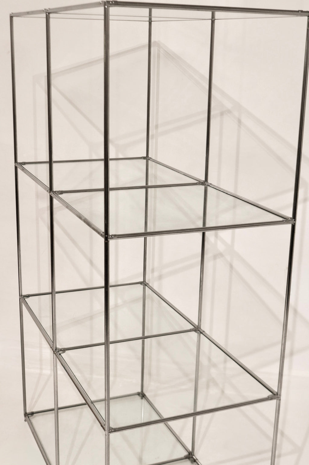 Full vertical view of the modular steel and glass shelving unit showing 3 tiers