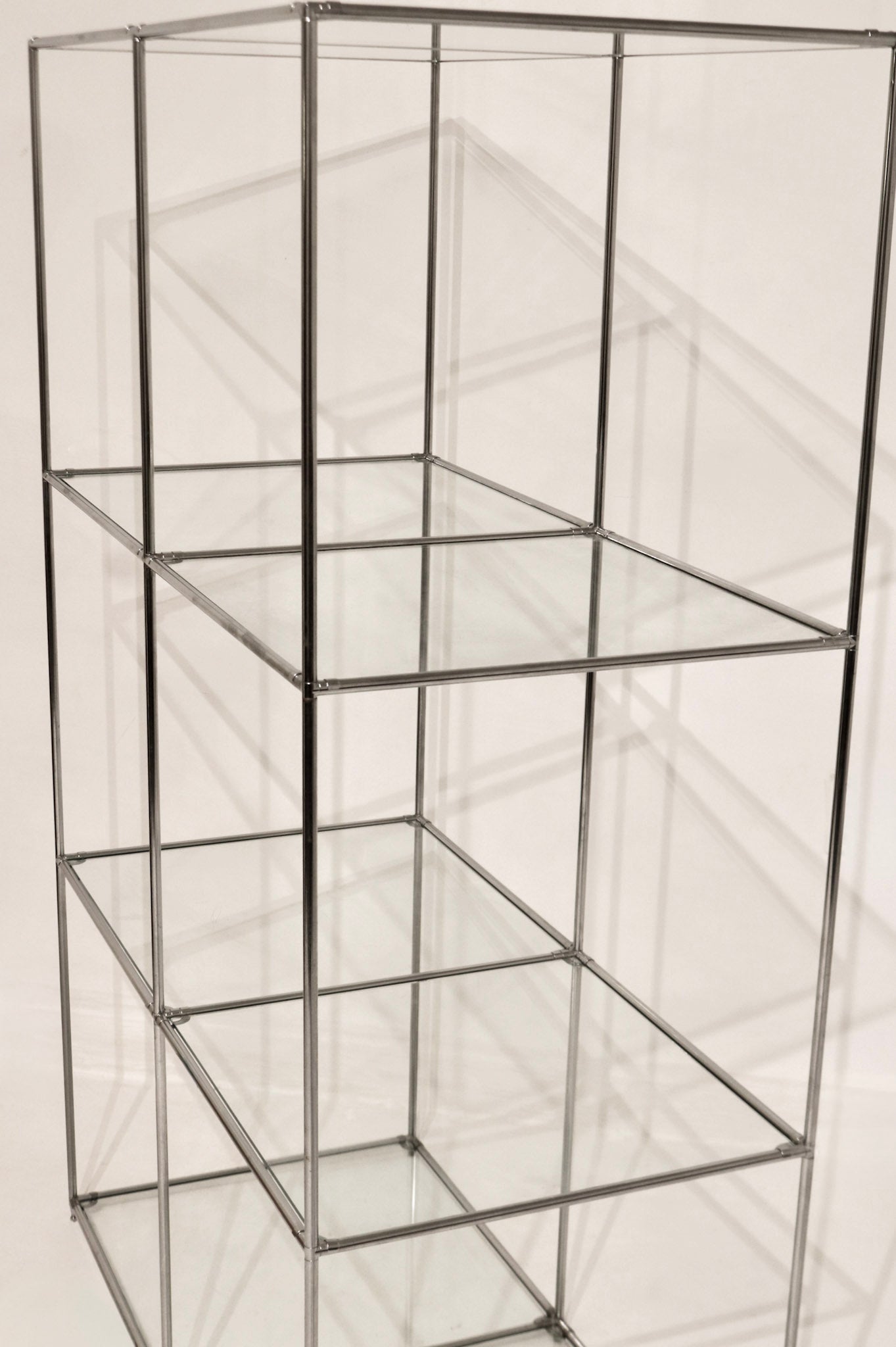 Full vertical view of the modular steel and glass shelving unit showing 3 tiers