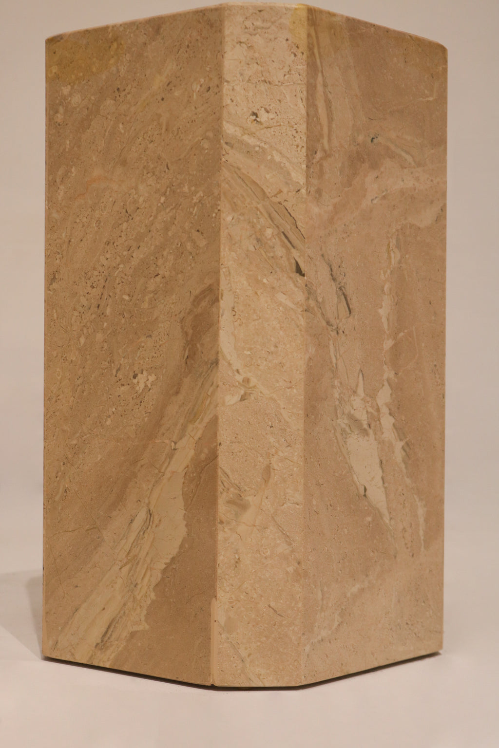 Side view geometric marble pedestal base showing solid construction