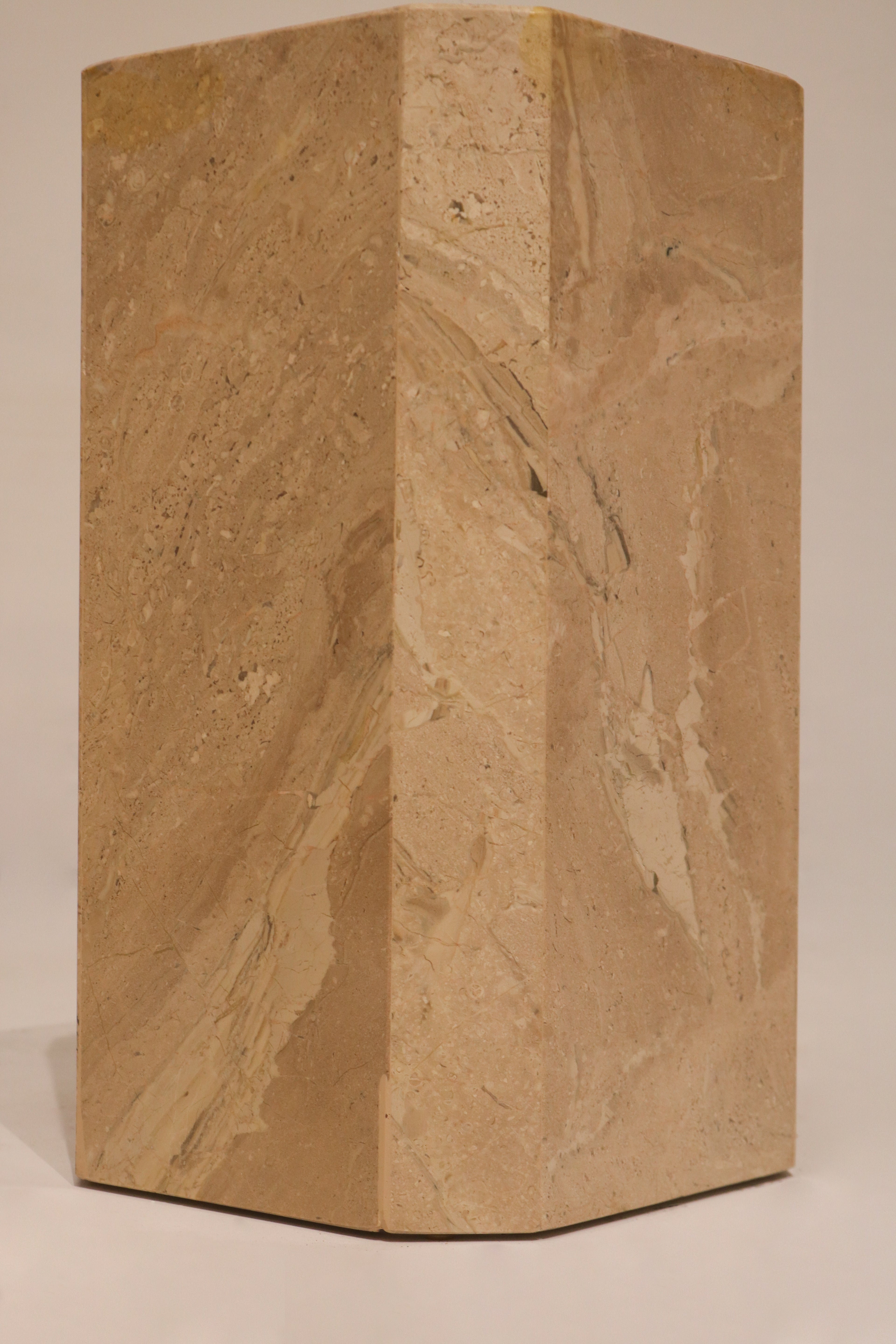 Side view geometric marble pedestal base showing solid construction