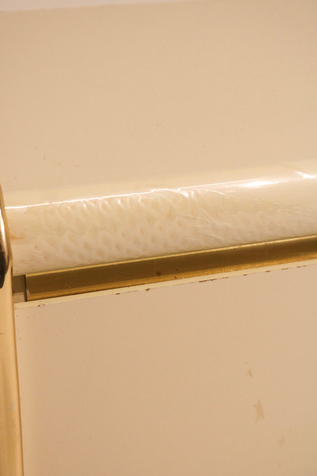 Close-up detail showing wear and condition of the gold metal trim edge