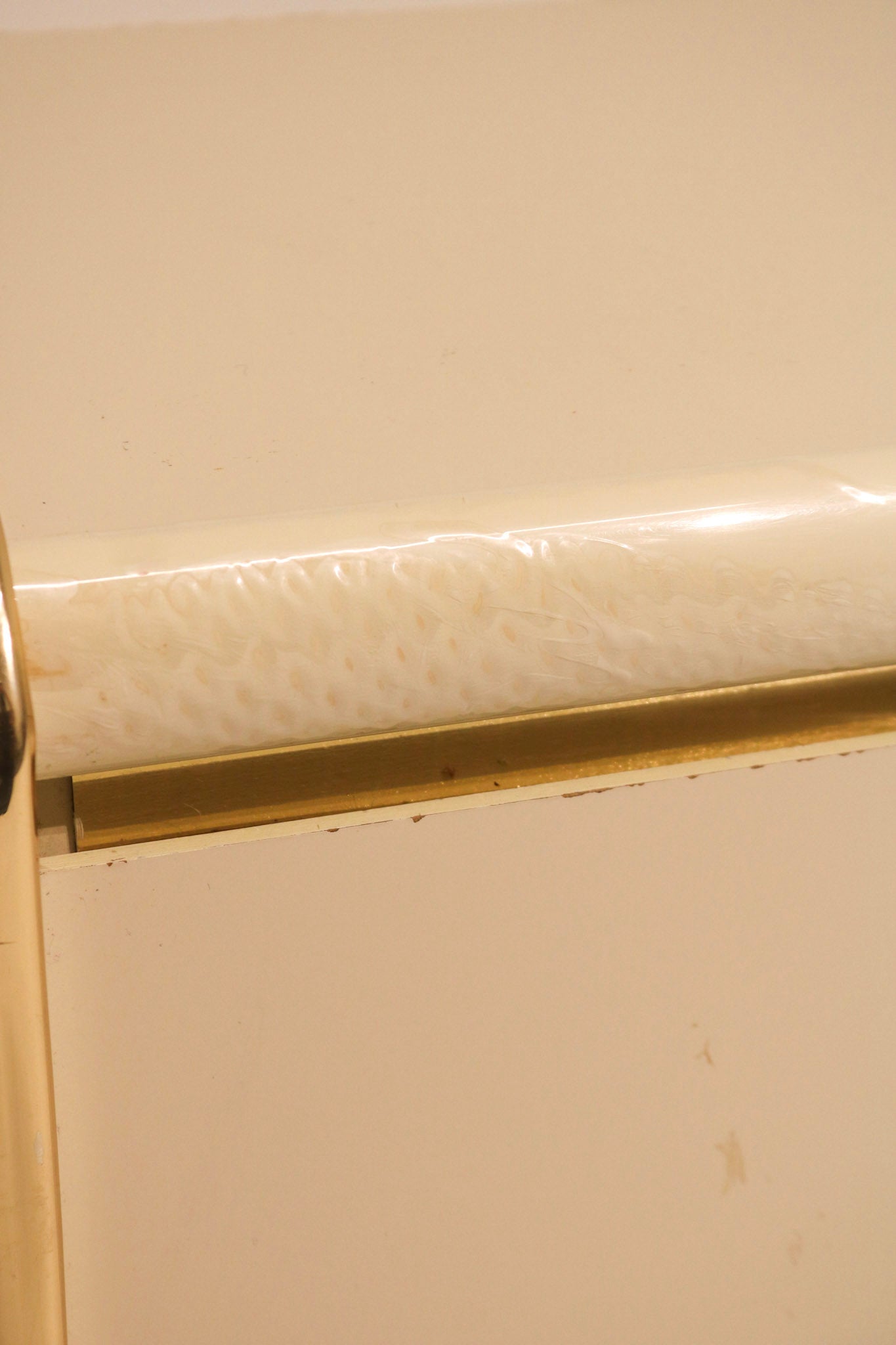 Close-up detail showing wear and condition of the gold metal trim edge