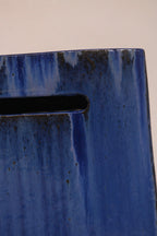 Detail of the rectangular handle cutout on the side of the ceramic stool"