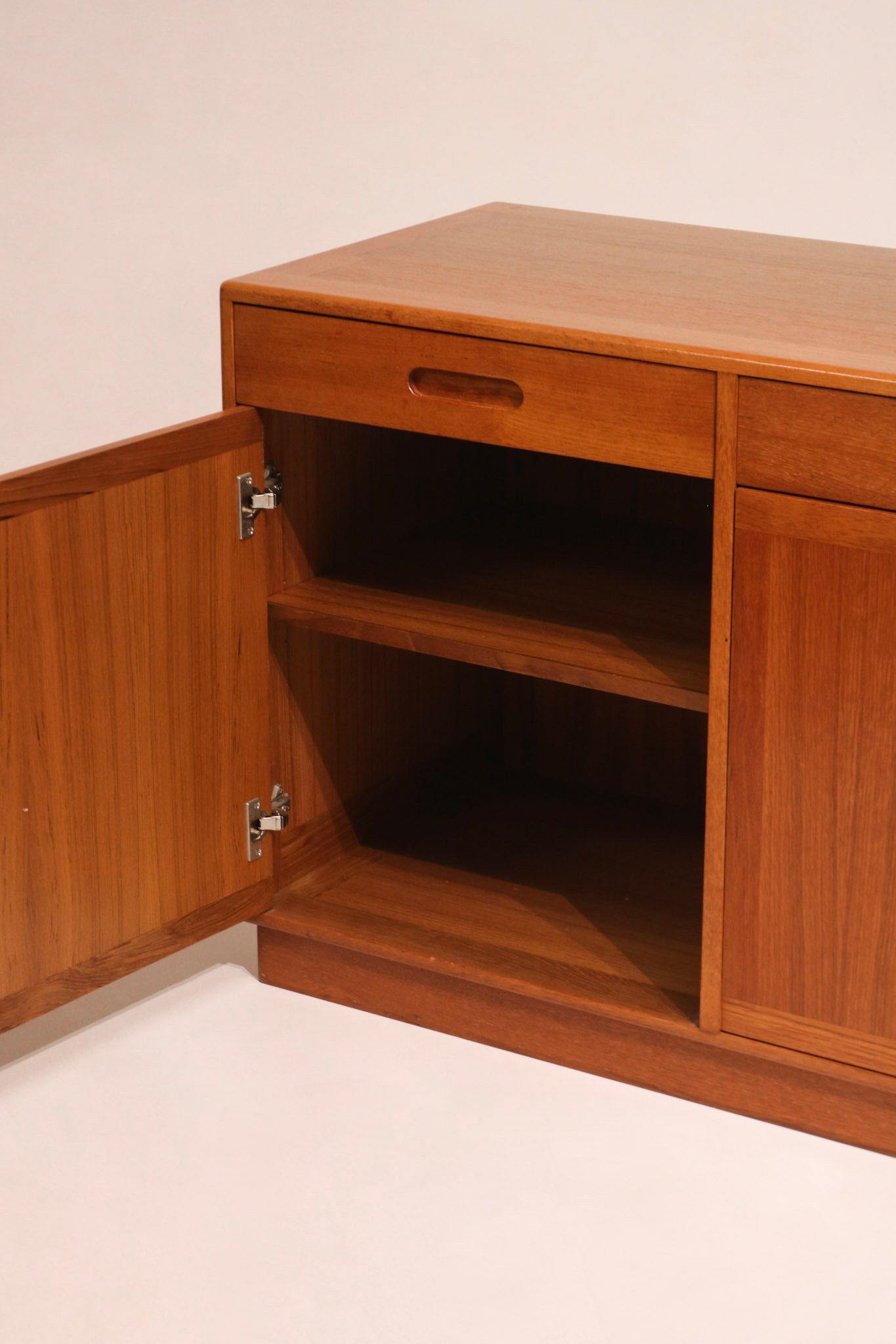 Close-up of the integrated teak handle characteristic of Danish design