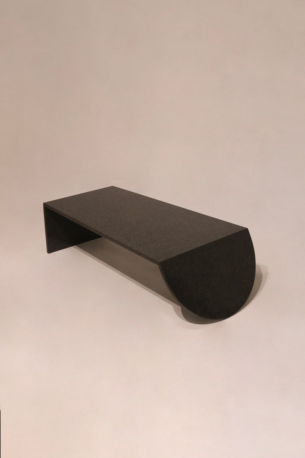 Full angled view showing sculptural geometric design of black stone coffee table