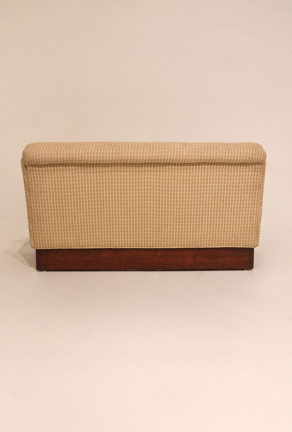 Rear view of beige fabric loveseat showing solid wood base and clean lines