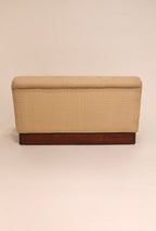 Rear view of beige fabric loveseat showing solid wood base and clean lines