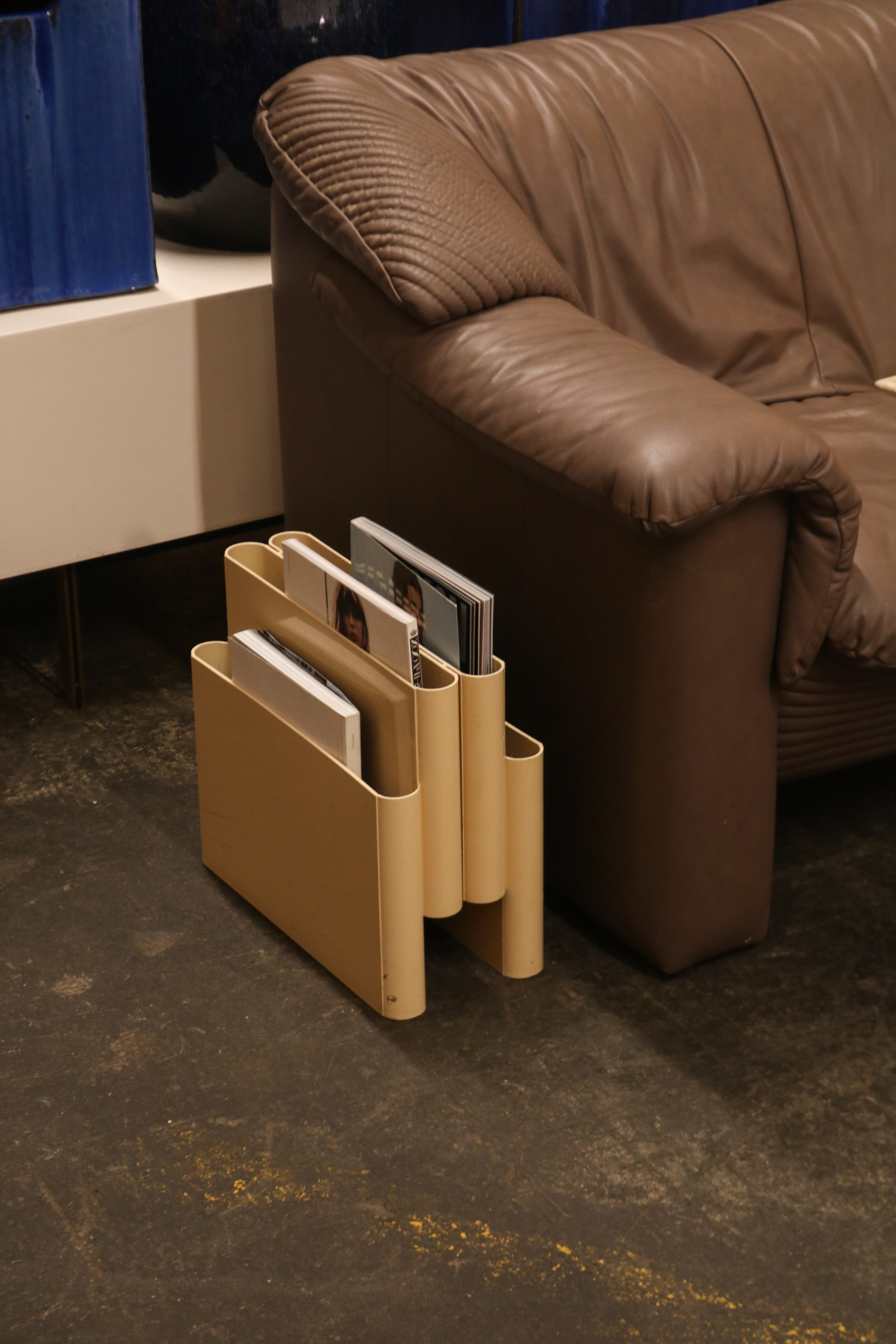 Vintage magazine rack placed next to sofa in living room setting
