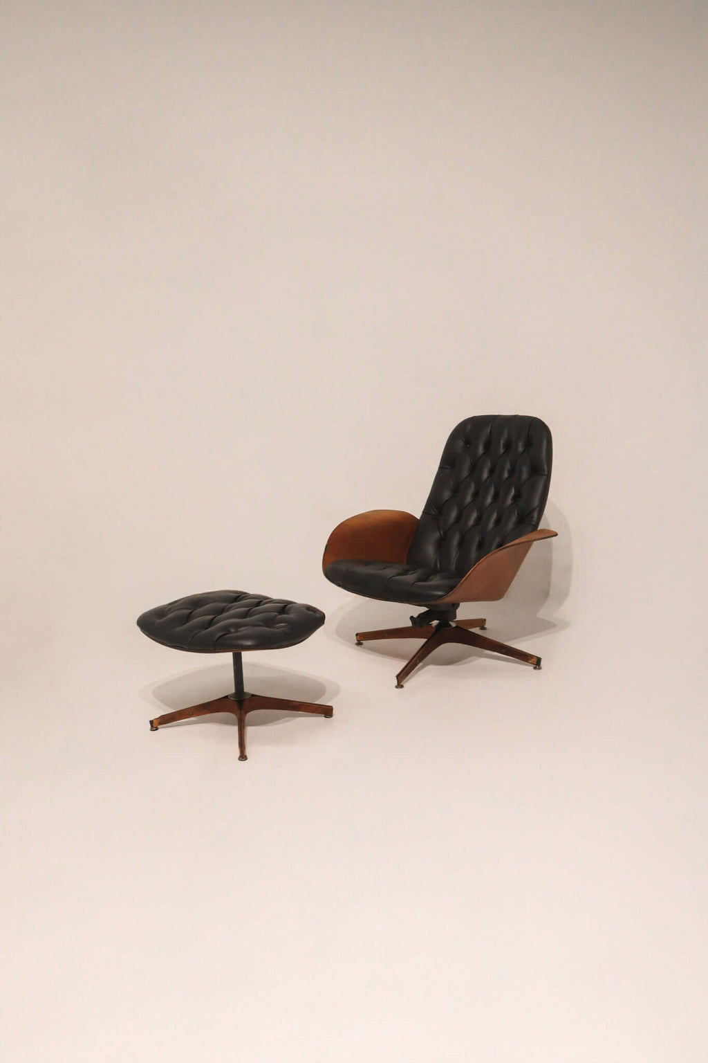 Mid Century Modern lounge swivel chair and ottoman by George Mulhauser black tufted leather