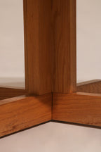 Angular profile view of oak cross base showing sturdy support and design