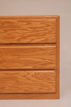Detail of oak drawer fronts showing natural wood grain and integrated pulls
