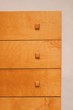 Close-up of oak veneer drawer fronts with matching wood knobs