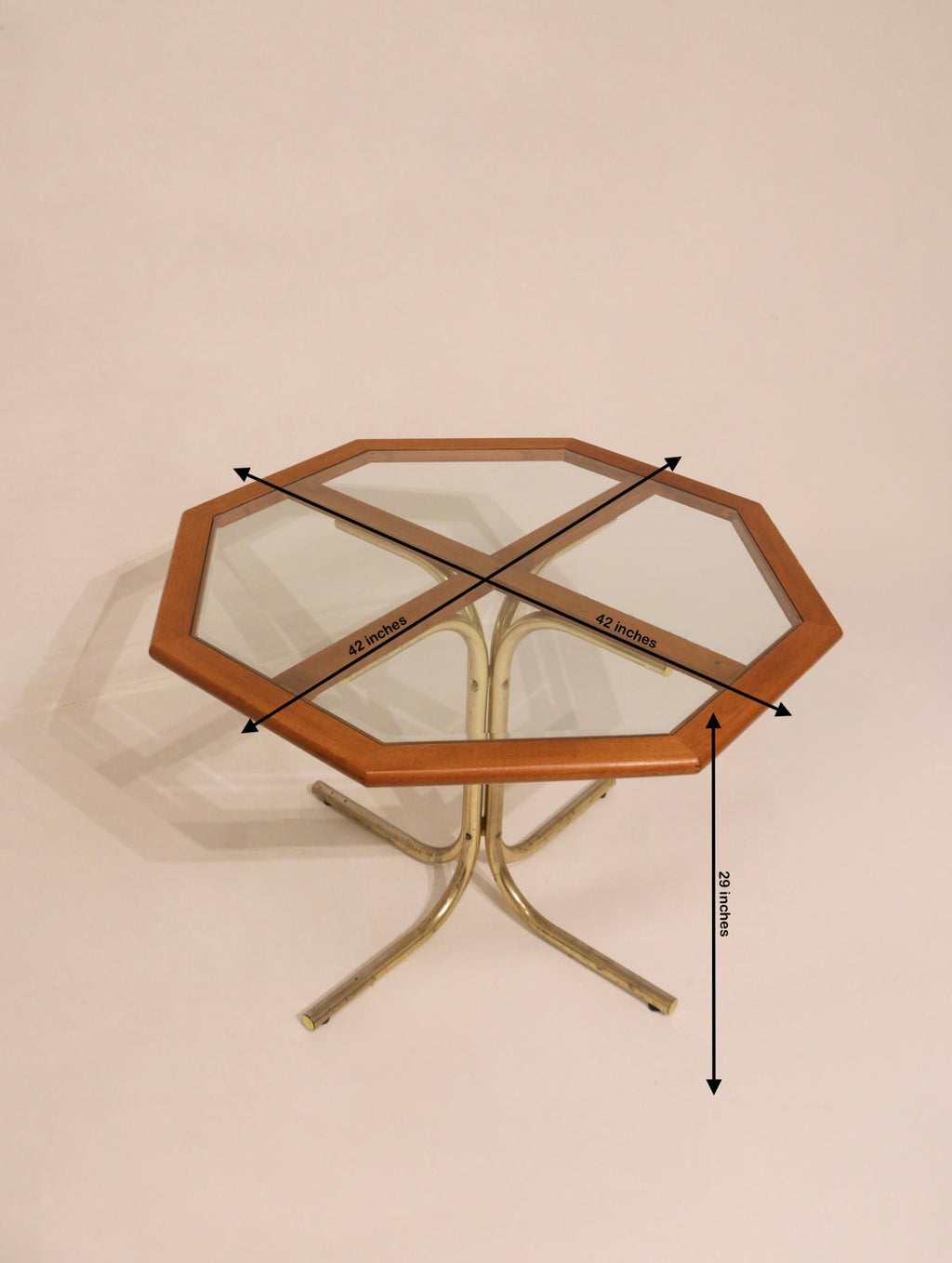 High angle view of octagonal glass table with wood frame and metal base