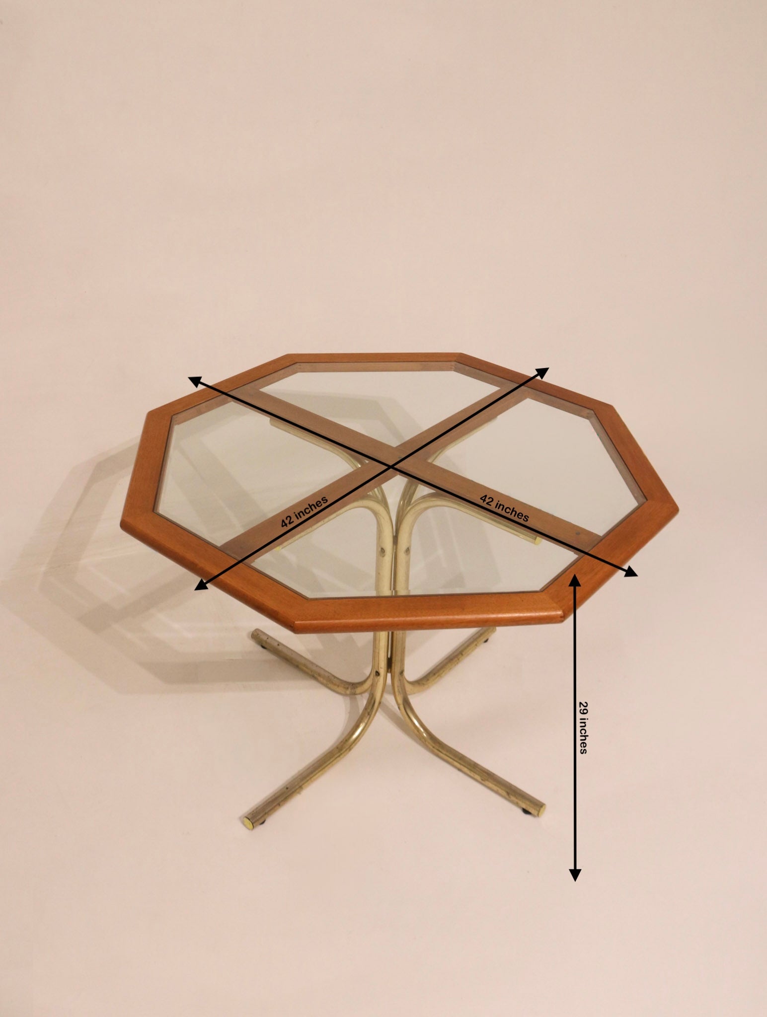 High angle view of octagonal glass table with wood frame and metal base
