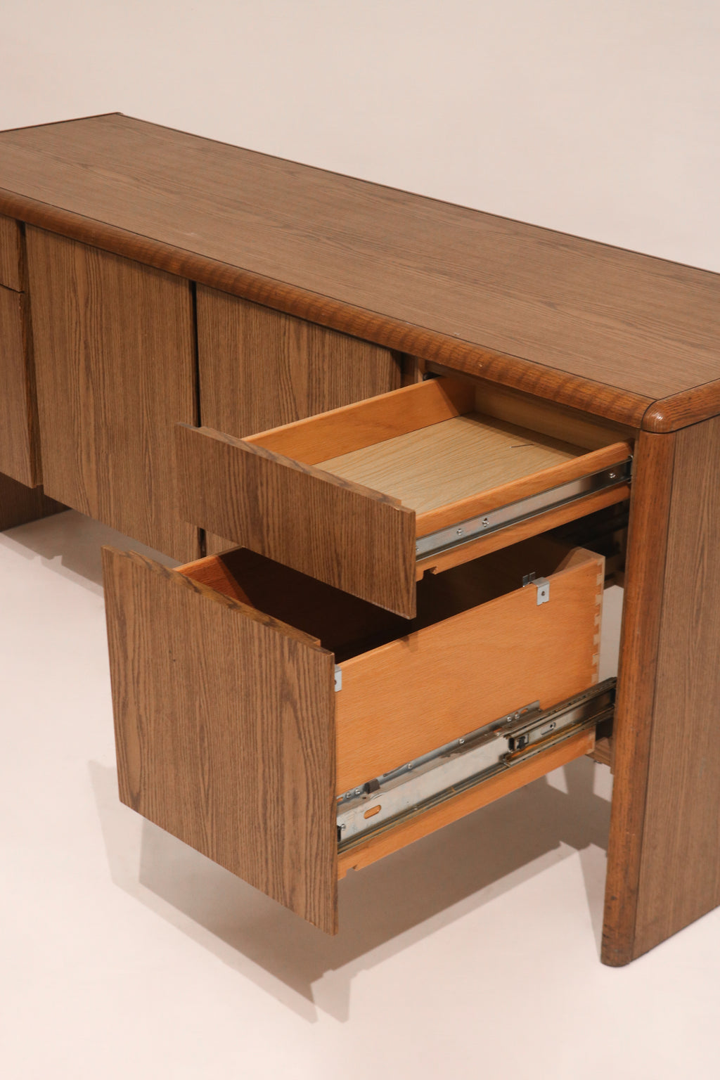 Angled view of open drawers showing depth and storage capacity of oak sideboard