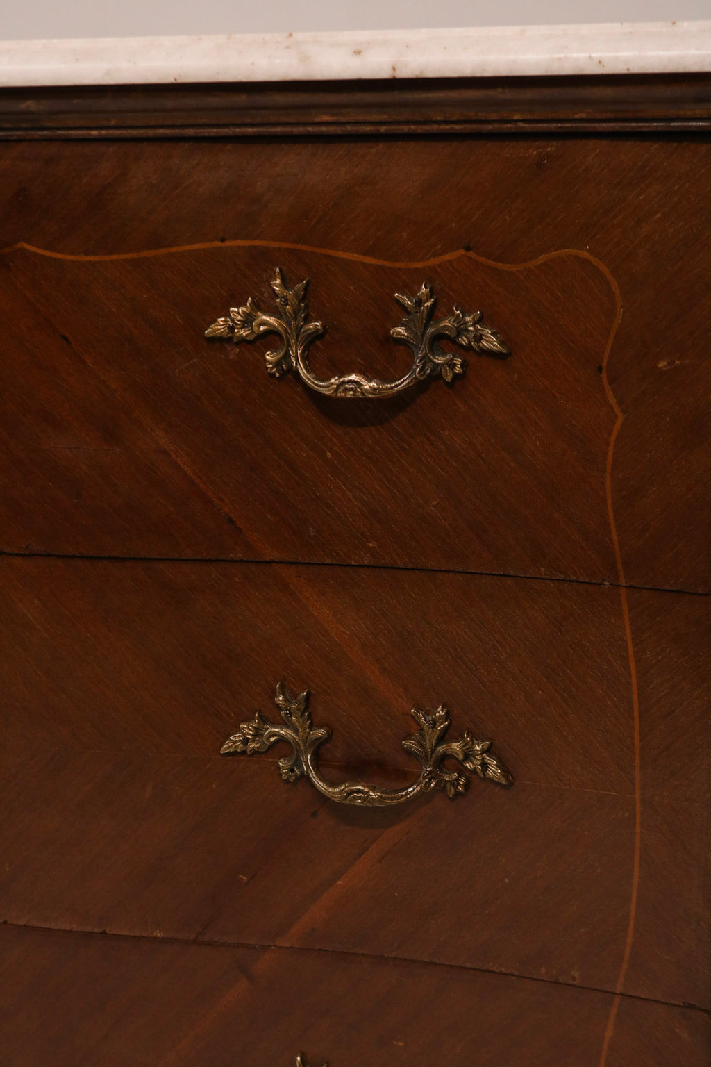 Close-up of ornate brass drawer pulls and hardware