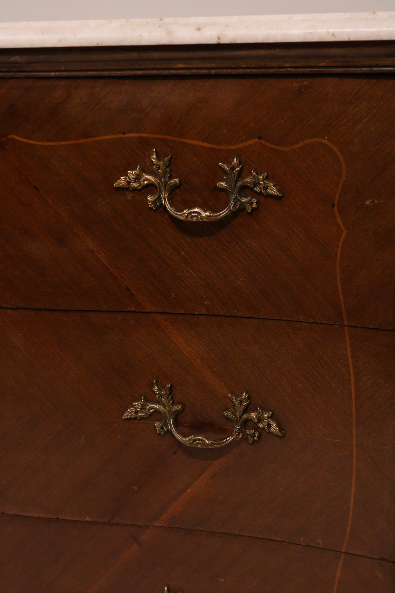 Close-up of ornate brass drawer pulls and hardware