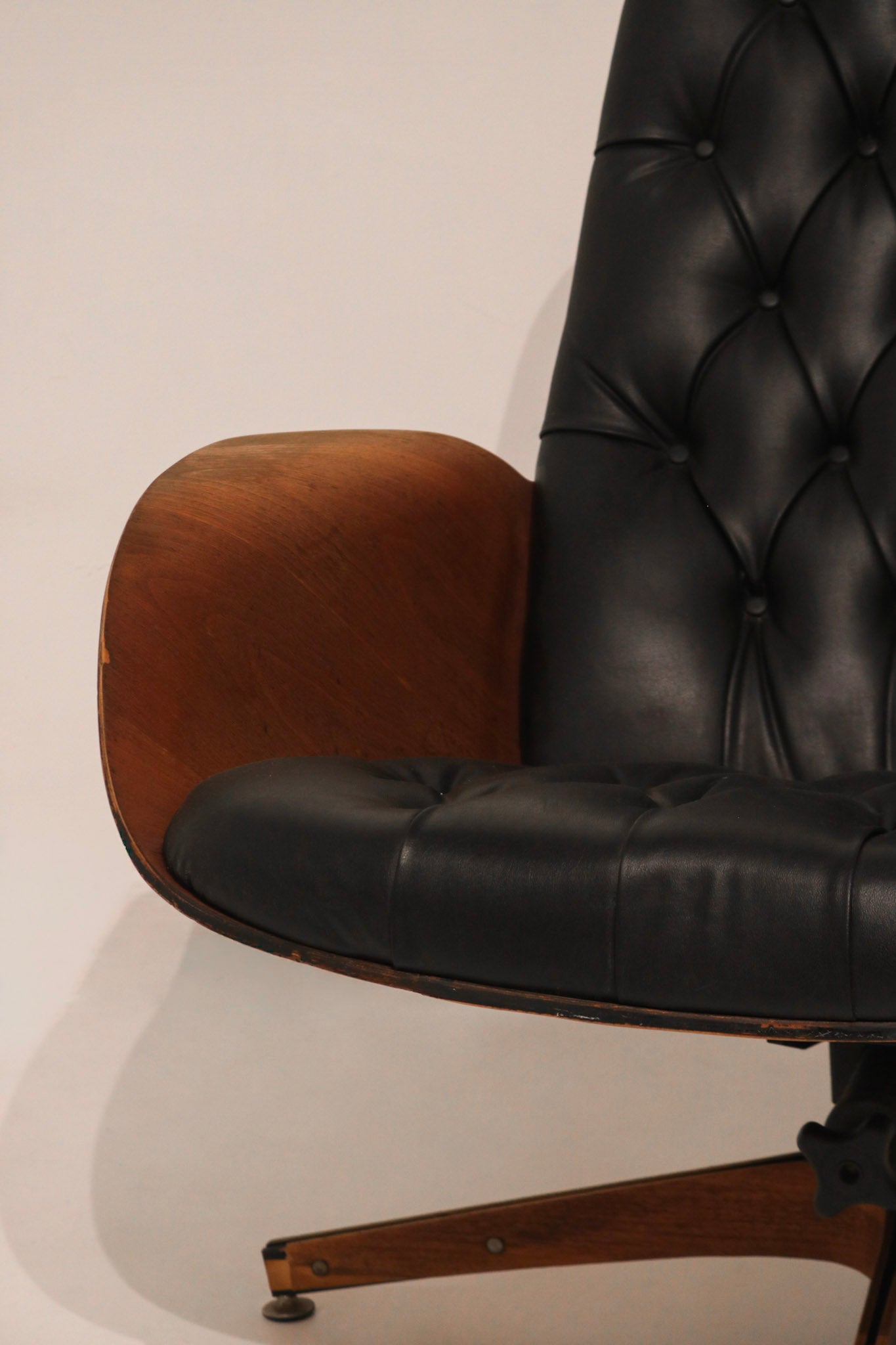 Detail of ottoman leg showing wear on the wood finish