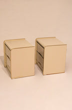 Angled view of two cream lacquer bedside tables showing matching set condition