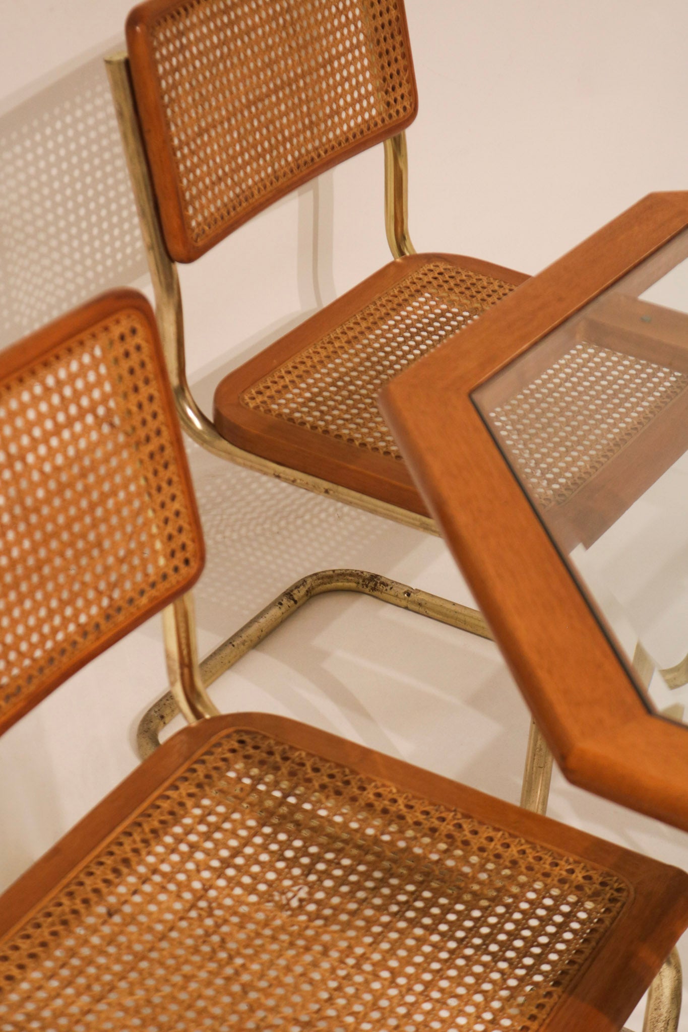 Rear view of chair showing cane backrest and metal frame support