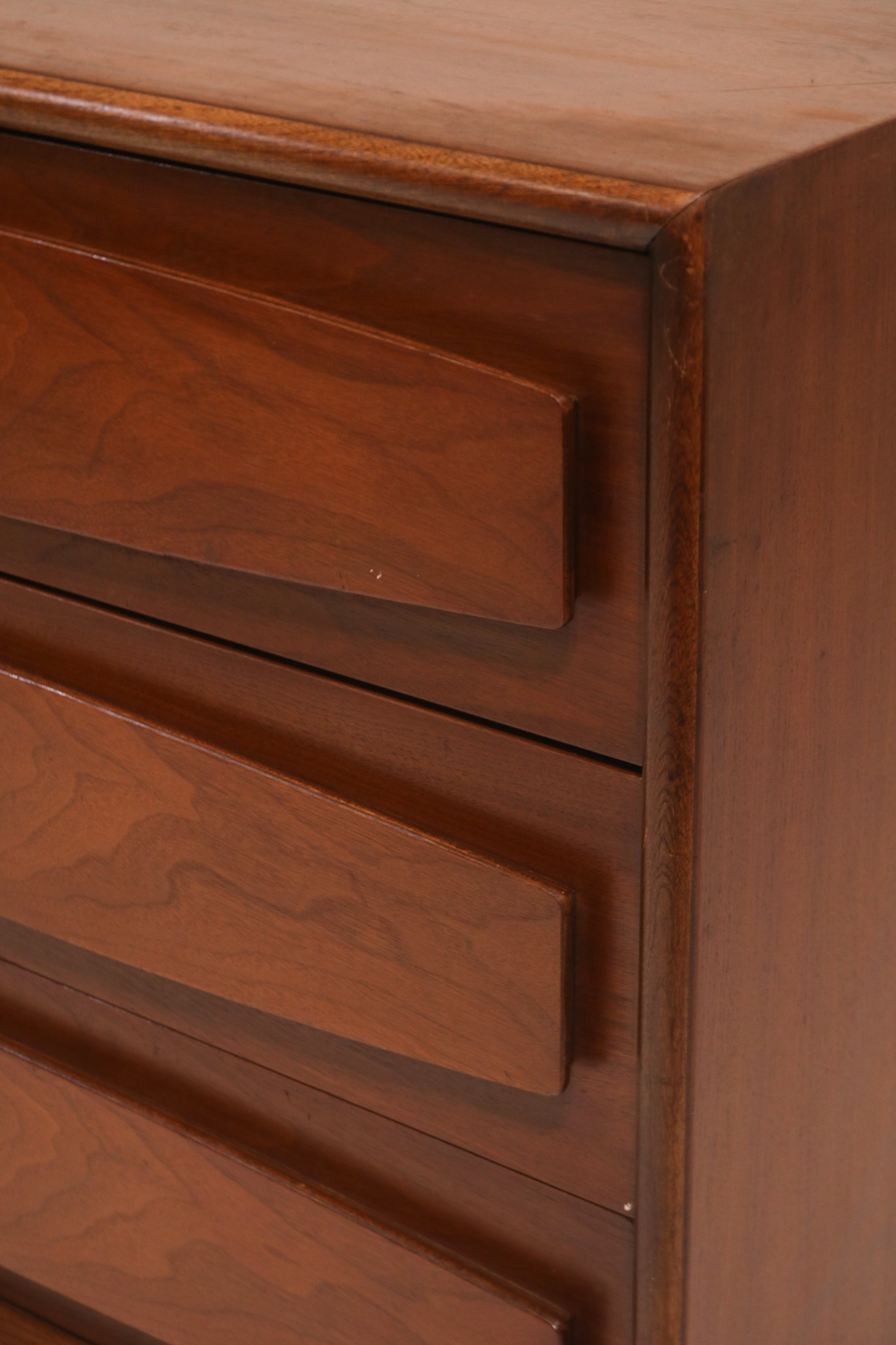 Detail of right side drawers with sculpted fronts and walnut texture