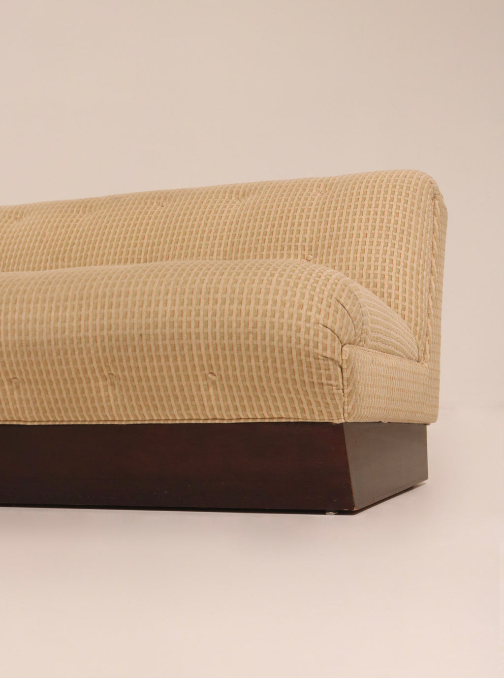 Right side profile view highlighting textured beige fabric and wood base