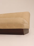 Right side profile view highlighting textured beige fabric and wood base