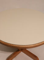 Top view of round dining table showing white formica cover and wood base