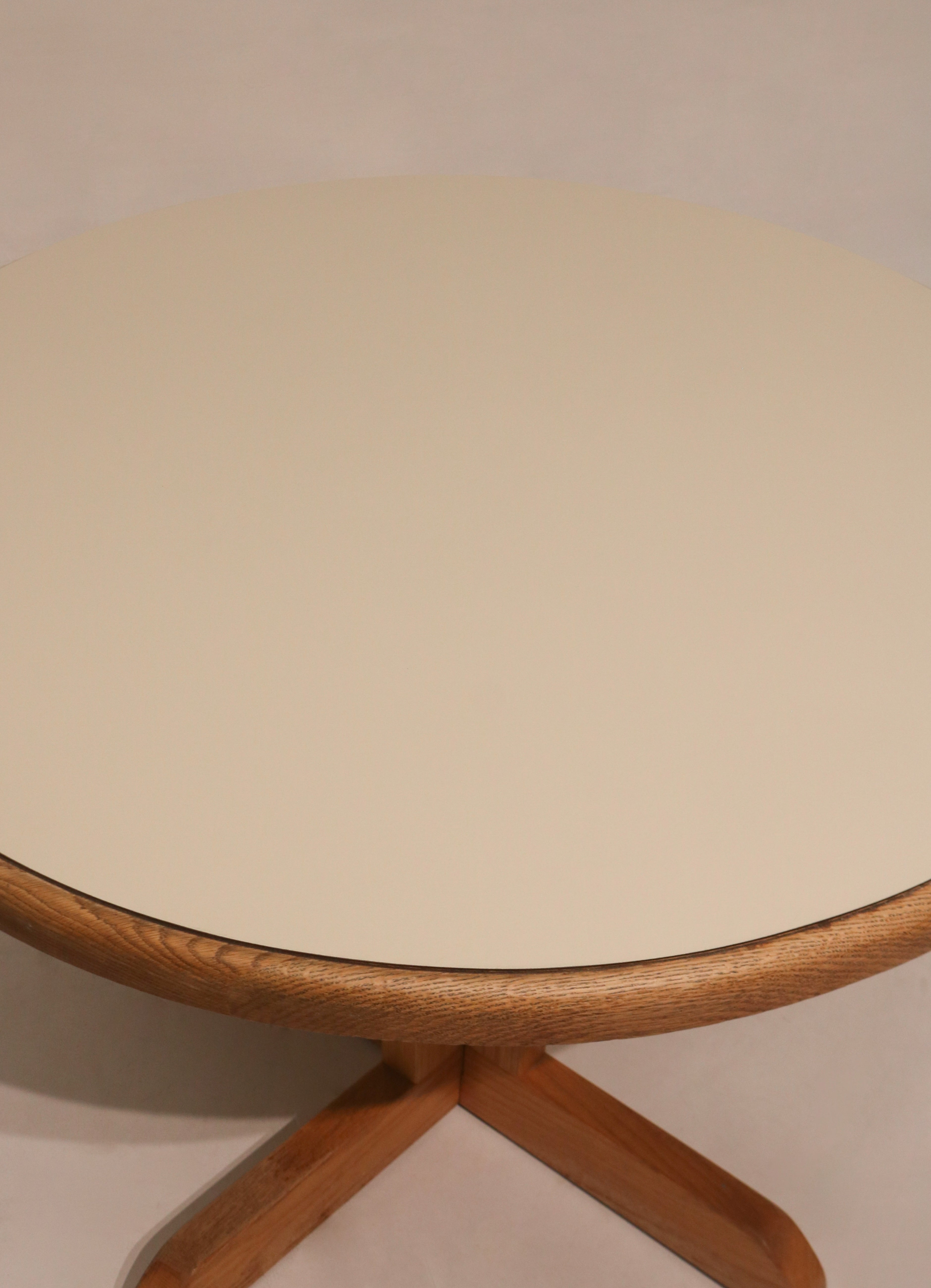 Top view of round dining table showing white formica cover and wood base