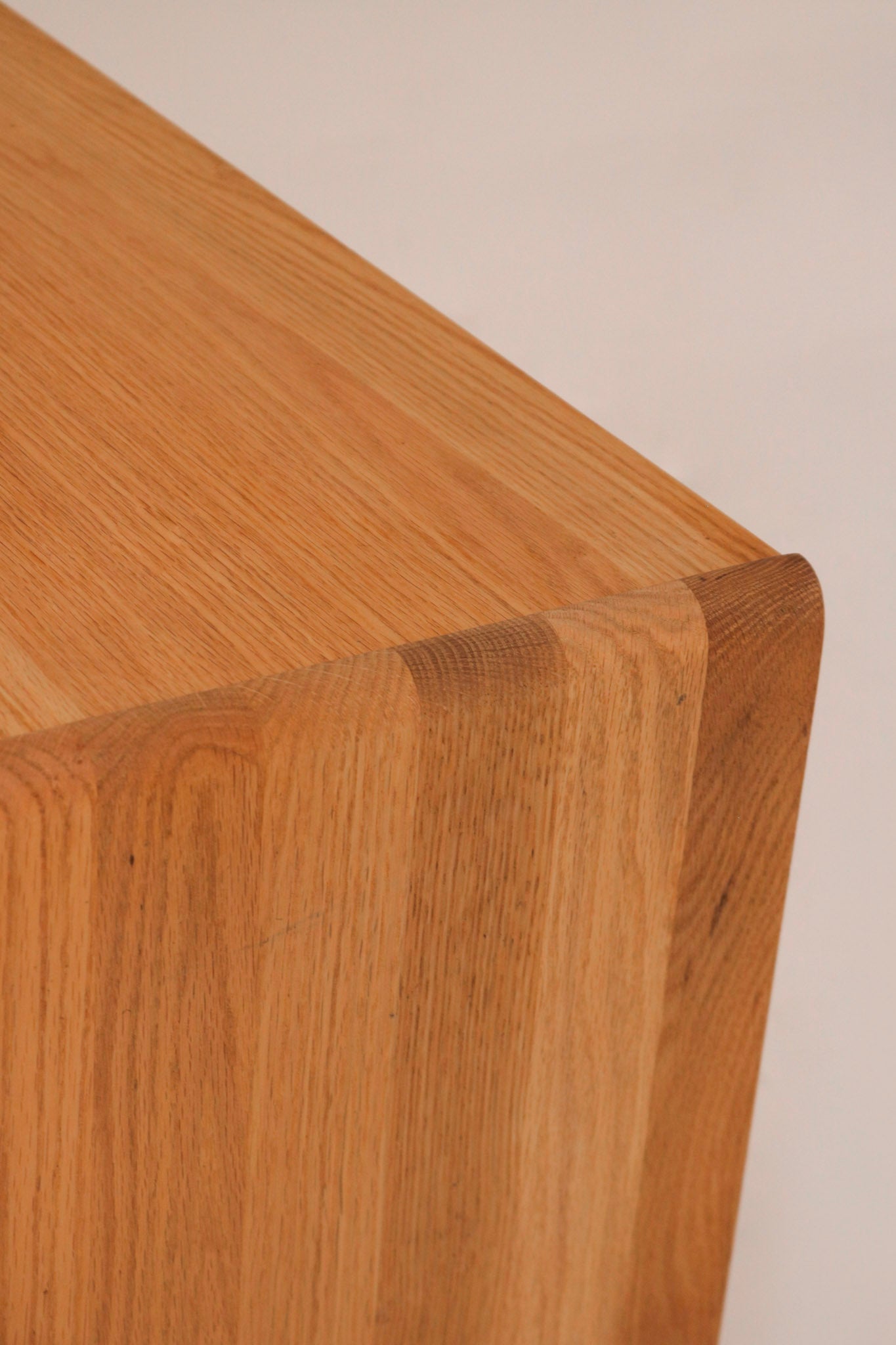 Close-up of rounded solid oak edge corner characteristic of CWD design