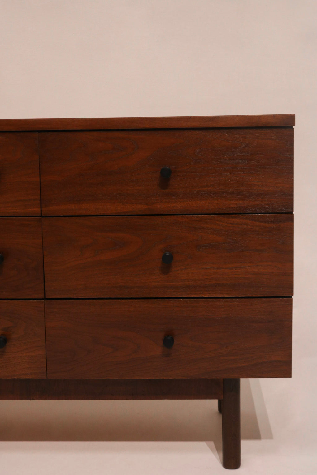 Close-up of sculpted walnut drawer pulls characteristic of the design