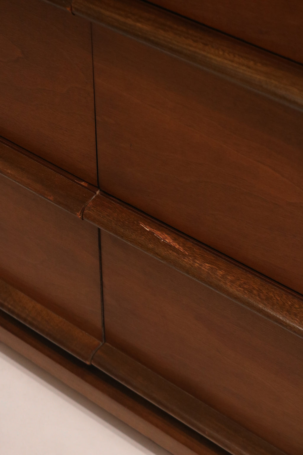 Close-up of the sculpted wood drawer pulls integrated into the design