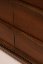 Close-up of the sculpted wood drawer pulls integrated into the design