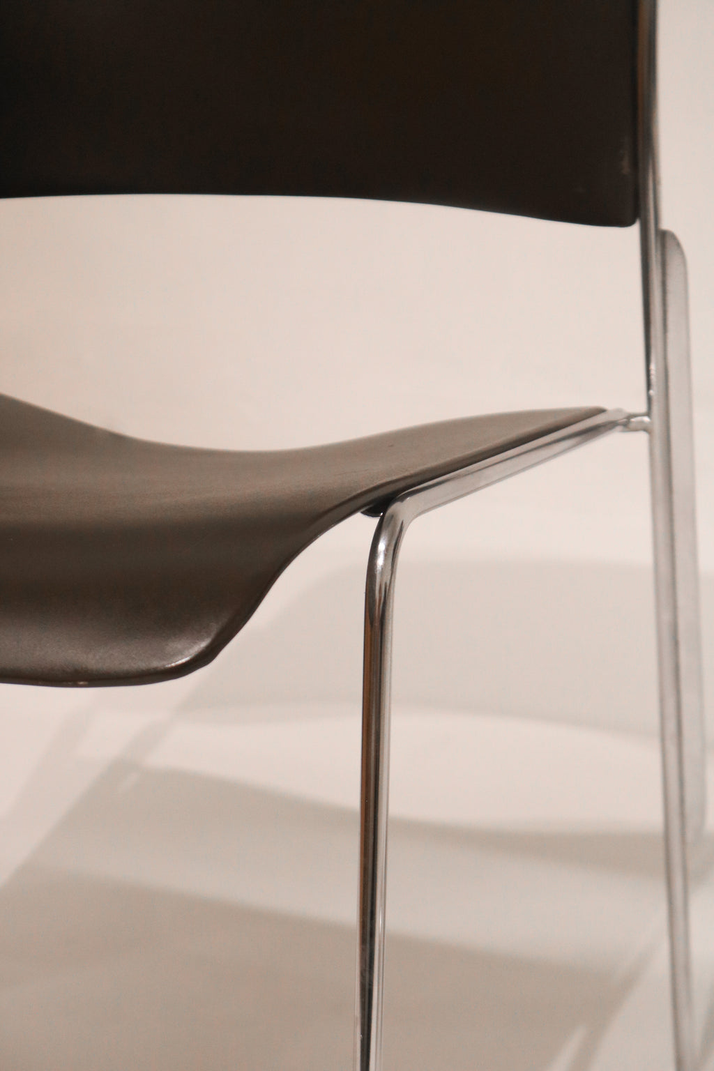 Close-up side view of seat-to-frame connection hardware and chrome finish