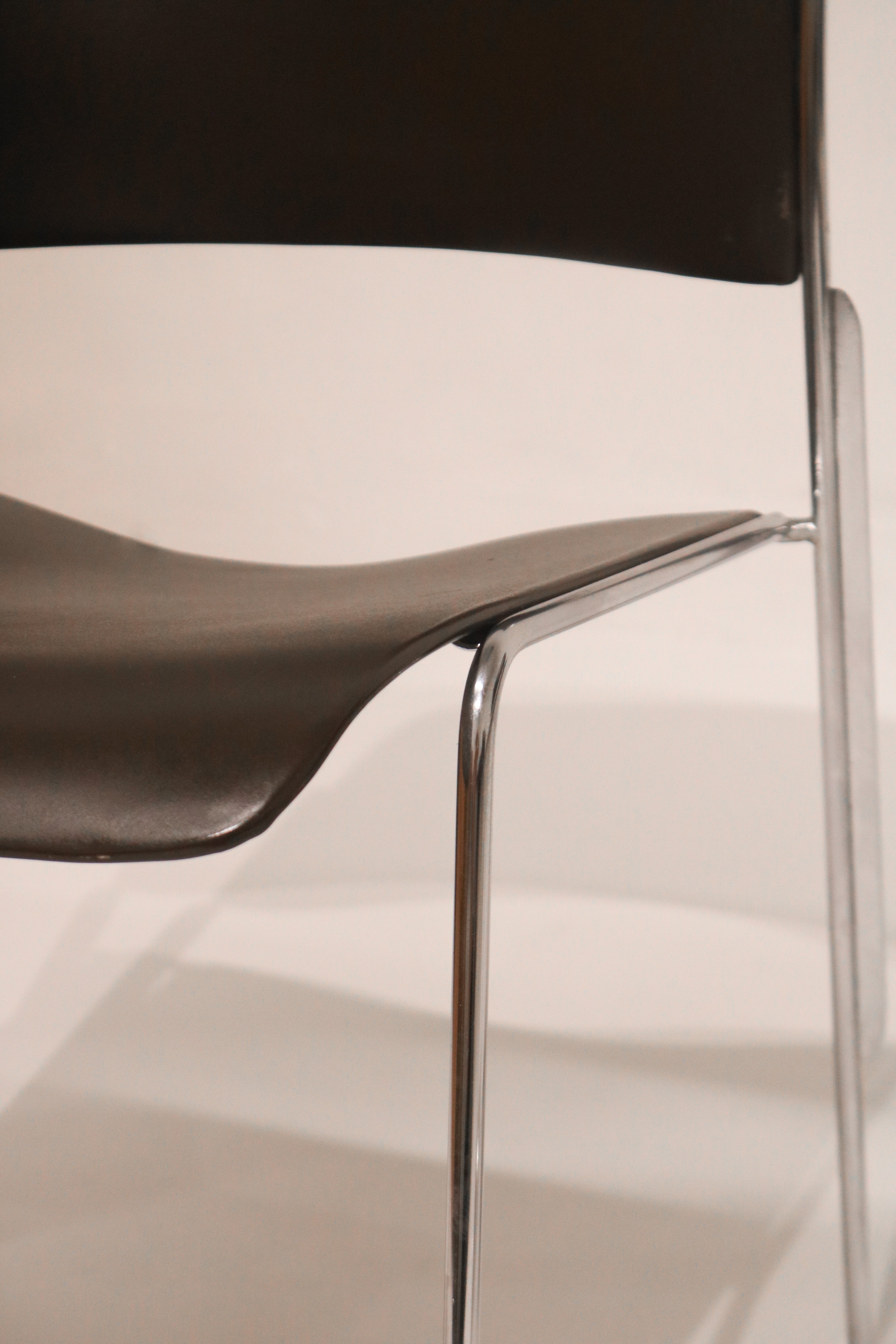 Close-up side view of seat-to-frame connection hardware and chrome finish