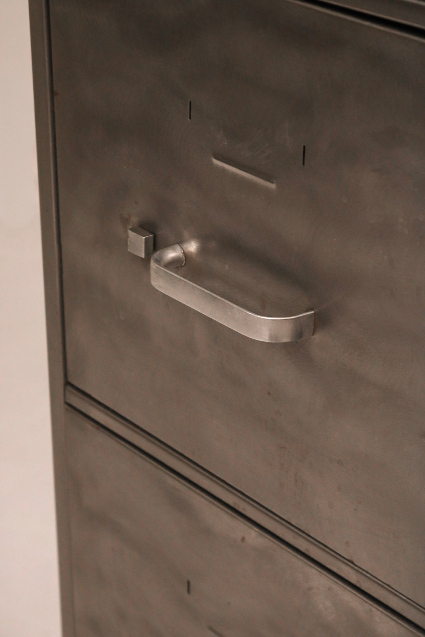 Angled view of side panel highlighting brushed metal texture and finish