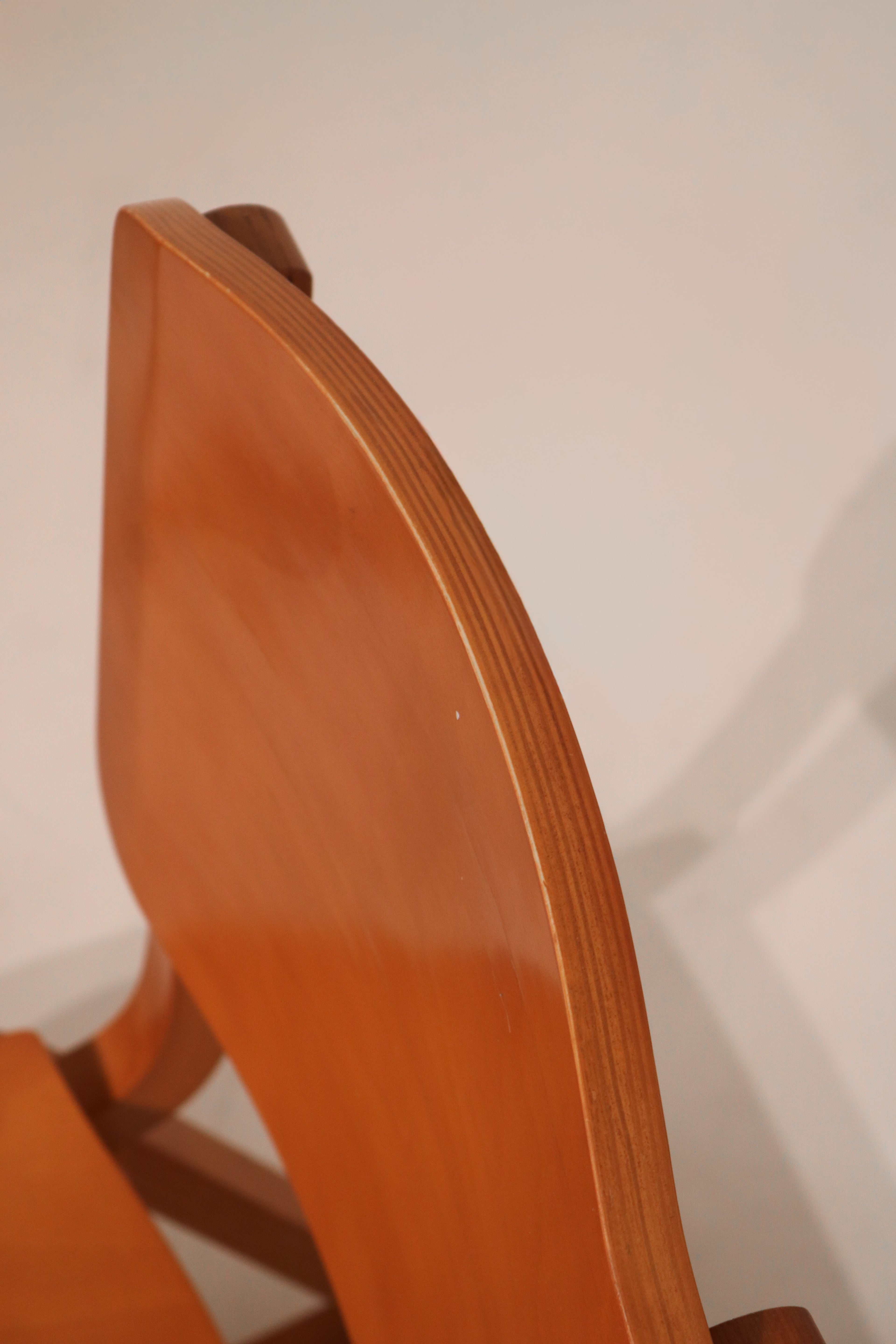 Side profile showing backrest curvature and layered plywood edge