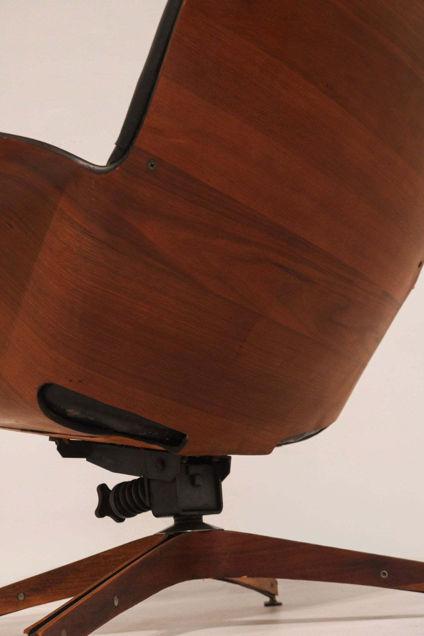 Side profile showing the ergonomic curve of the plywood shell and leather seat