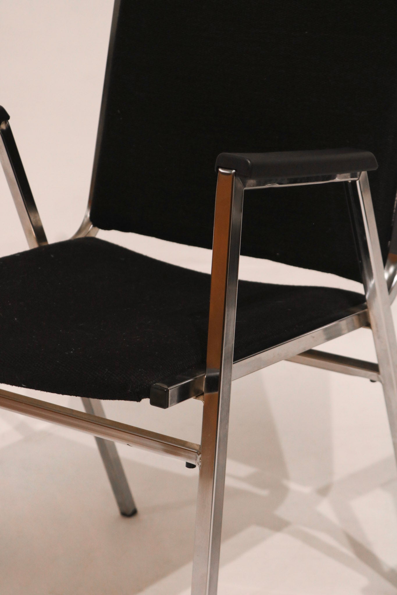 Three quarter angle view of single stackable arm chair MCM steel chrome frame