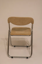 Front view of single deployed chair showing chrome frame and beige seat