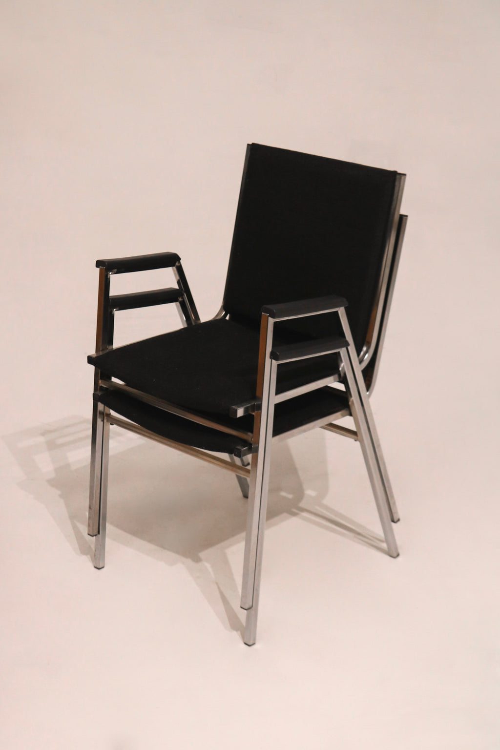 Stacked arm chairs showing space-saving design vintage steel frame