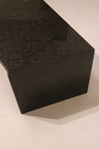 Side view of rectangular block end support on modern stone coffee table
