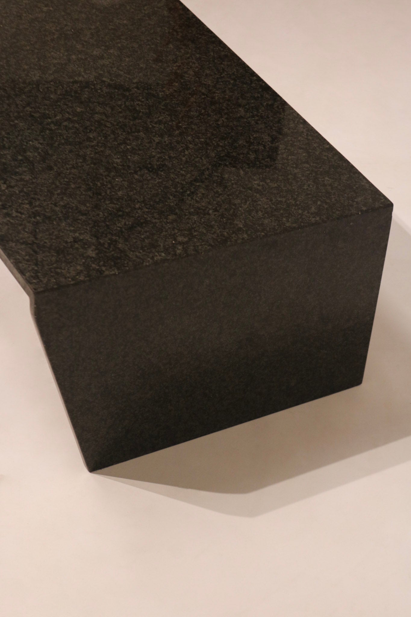 Side view of rectangular block end support on modern stone coffee table