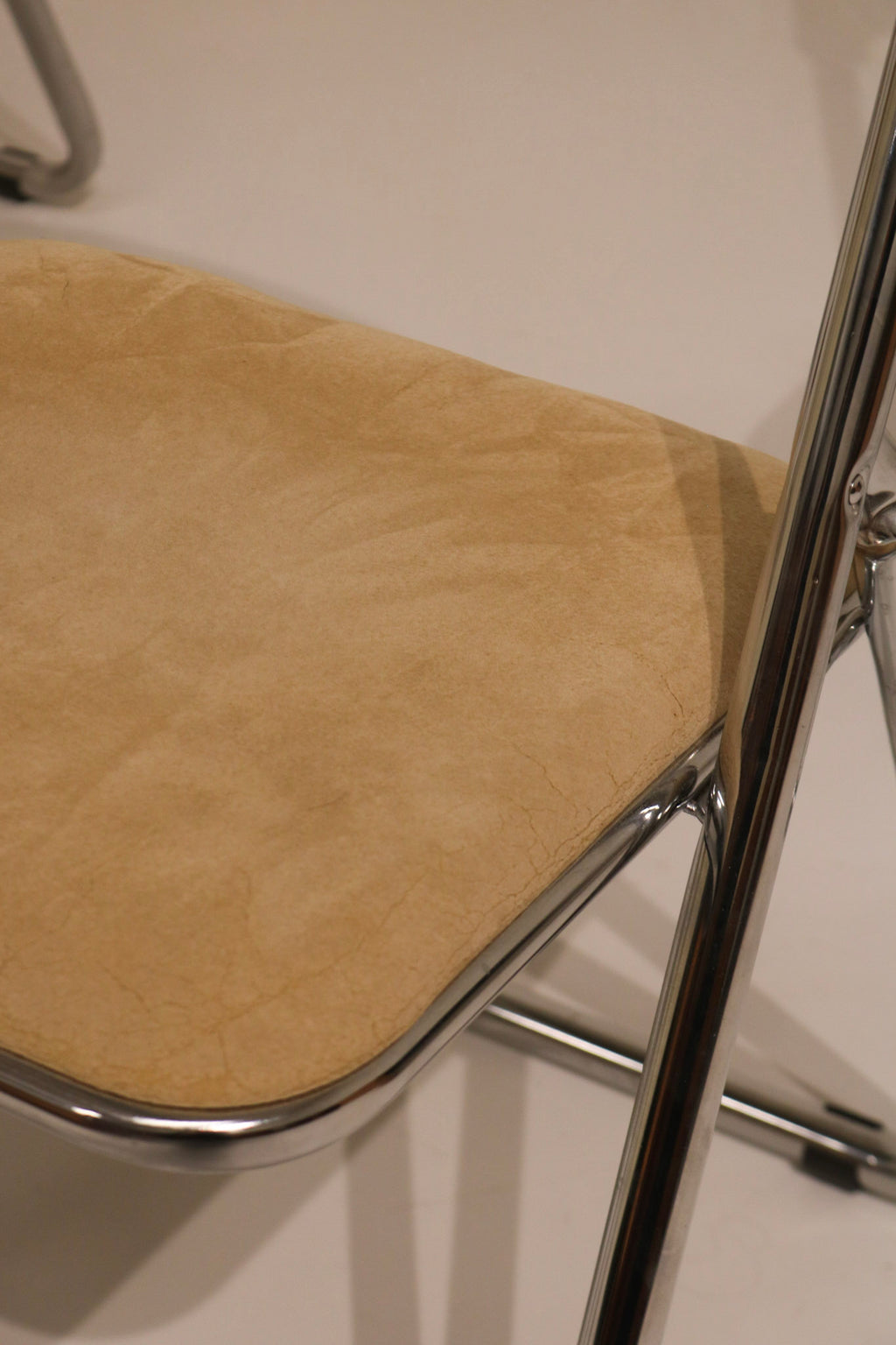 Studio shot of single beige velvet folding chair on white background