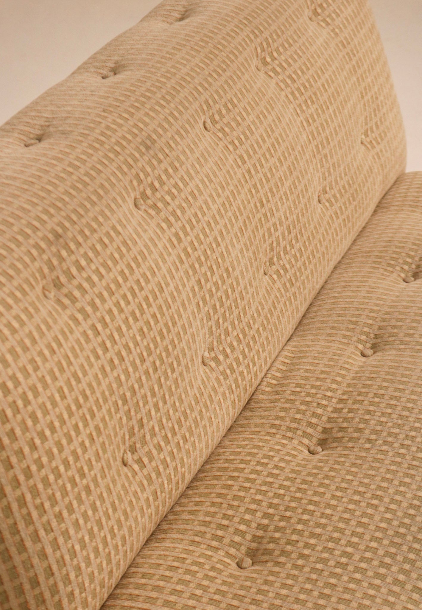 Close-up of textured fabric backrest showing button tufting detail