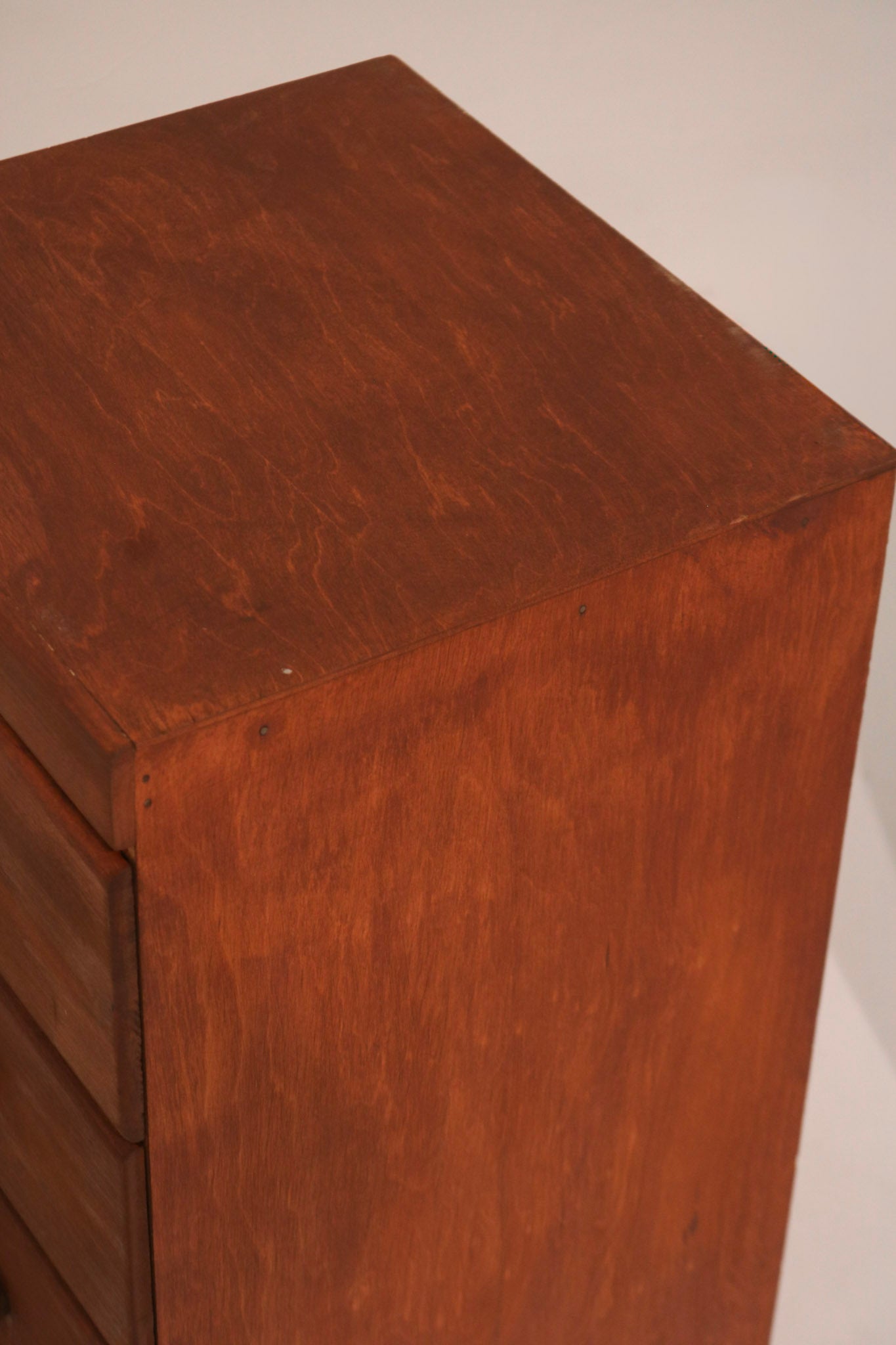 Detail of top corner edge showing wood grain pattern and finish wear